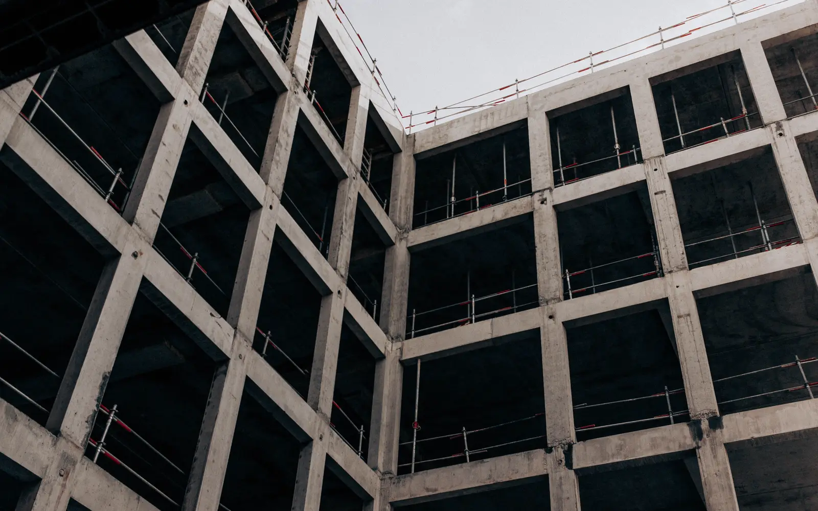 Concrete frame of a multi-story commercial building under construction, seen from below
