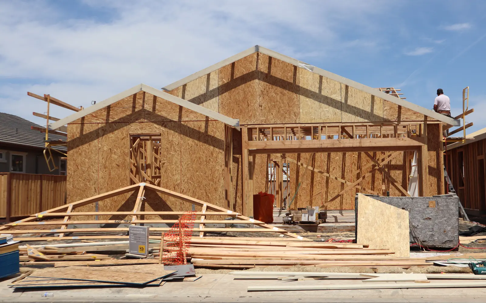 Timber framing of a new two-story home under construction on a clear day